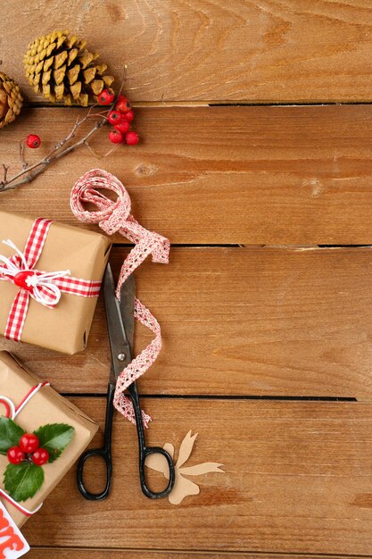 Schöne Weihnachtskomposition mit handgemachten Geschenken auf Holzuntergrund