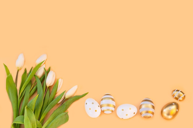 Foto schöne weiße tulpen mit bunten ostereiern auf hellem hintergrund