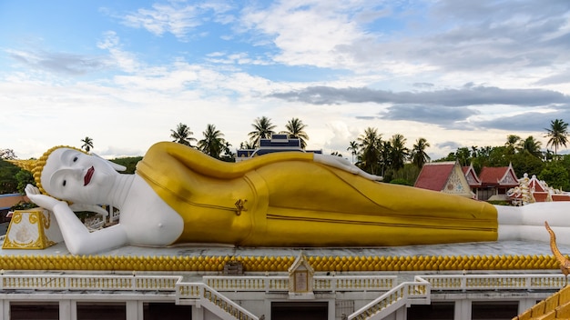 Schöne weiße und goldene Buddha-Statuen in der Liegeposition unter dem blauen Himmel am Abend im Wat That Noi, es ist ein buddhistischer Tempel, ein Wahrzeichen der Provinz Nakhon Si Thammarat, Thailand