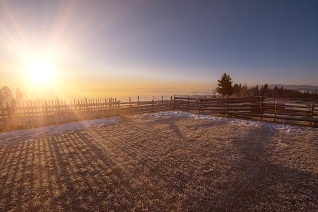 Schöne Winterlandschaft bei Sonnenuntergang über schneebedecktem Feld