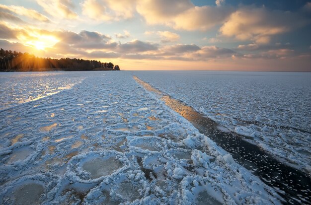 Foto schöne winterlandschaft mit sonnenunterganghimmel und zugefrorenem see