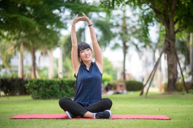 Schöne Yogafrau auf grünem Park