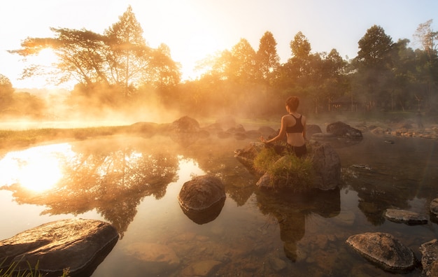 Foto schöne yogafrau morgens am park der heißen quelle.