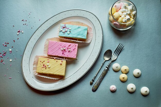 Foto schöne zarte shortbread-kuchen mit zuckerguss in zarten farben teeparty für den urlaub süßwarenkunst der blick von oben auf den hintergrund ist silbern