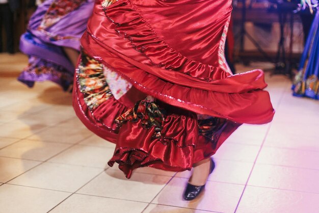 Foto schöne zigeunermädchen, die bei der hochzeitsfeier im restaurant in traditionellem roten blumenkleid tanzen frau, die roma-tanz und volkslieder in nationaler kleidung aufführt roma-zigeunerfest