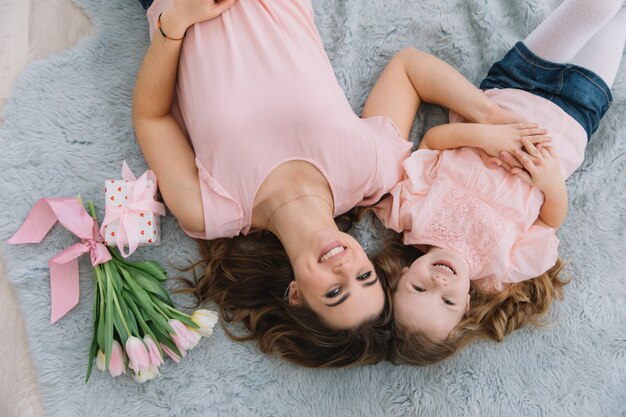 Schönen muttertag. kindertochter gratuliert mutter und gibt ihr blumentulpen und -geschenk