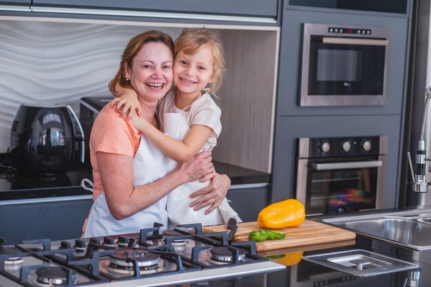 Schönen Muttertag! Kindertochter und Mutter kochen und haben Spaß in der Küche zu Hause. Familienurlaub und Zweisamkeit.