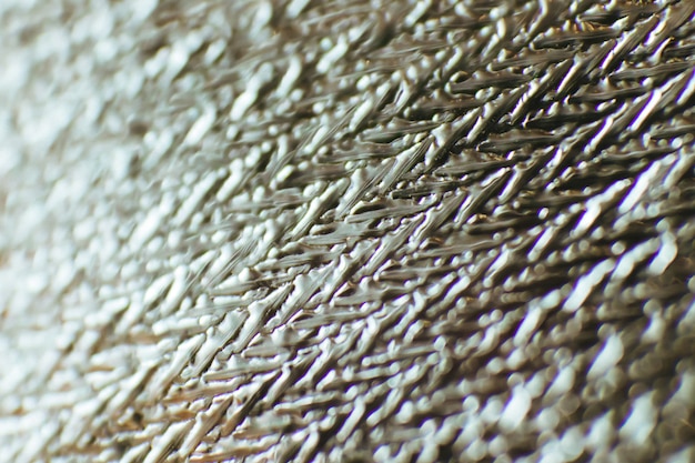 Schöner abstrakter Hintergrund aus Material. Die Textur von Aluminiumfolie. Weicher Fokus. Makrofotografie.