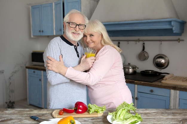 Schöner älterer Mann und Frau, die Mahlzeit kochen.