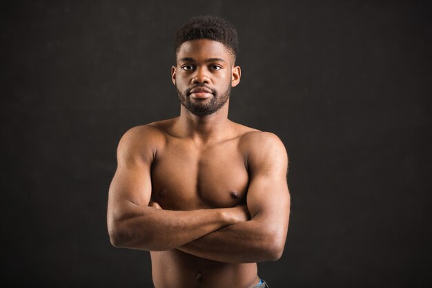 schöner afrikanischer Mann mit Muskeln auf schwarzem Hintergrund
