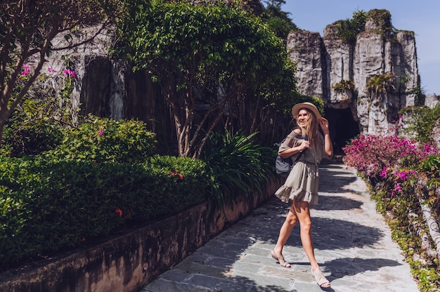 Schöner aufgeregter Blondinewanderer geht und bewundert tropische Landschaften im Paradiesinselhotel in Sanya, China.