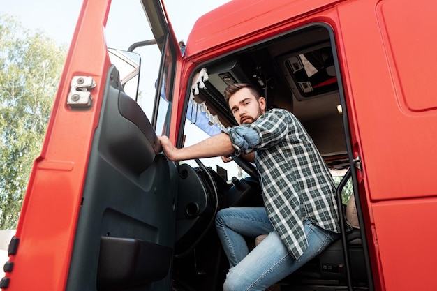 Schöner bärtiger LKW-Fahrer in seinem roten Lastwagen