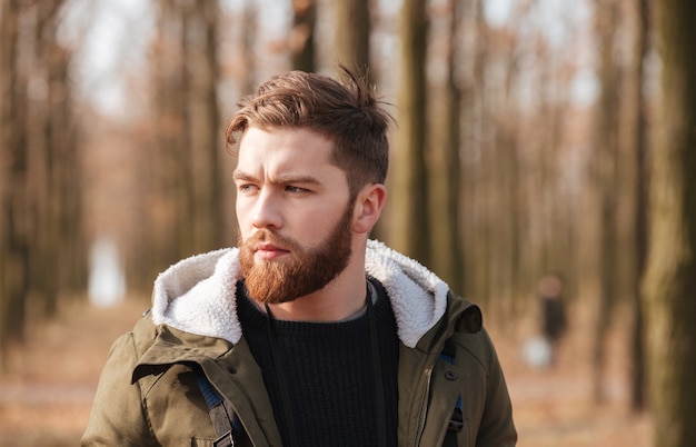 Schöner bärtiger Mann, der im Wald steht