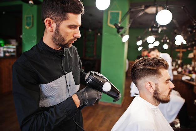 Schöner bärtiger Mann im Friseursalon bei der Arbeit