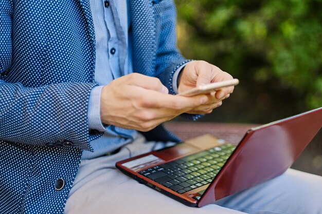 Schöner bärtiger Mann mit Laptop in einem Park.