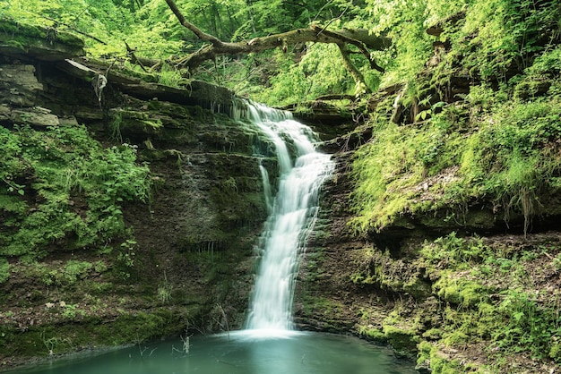 Schöner Bergregenwald Wasserfall mit schnell fließendem Wasser und Felsen Langzeitbelichtung Natürlicher saisonaler Outdoor-Hintergrund im Hipster-Vintage-Stil