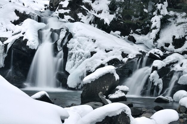 Schöner Bergwasserfall bedeckt mit Eis