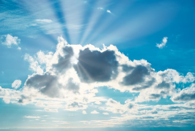 Schöner blauer Himmel mit Sonnenstrahlen und Sonnenstrahlen durch Wolken