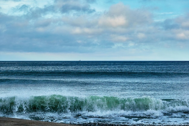 Foto schöner blick auf das meer mit spritzenden wellen gegen den dramatischen himmel