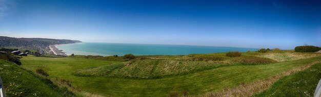 Schöner Blick auf das Meer und die grasbewachsene Landschaft vor dem blauen Himmel