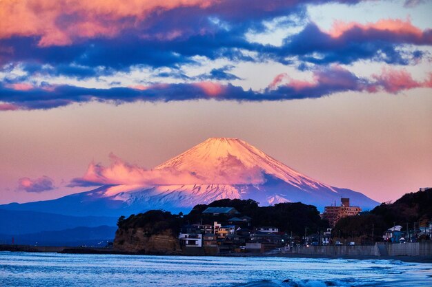 Schöner Blick auf das Meer und die schneebedeckten Berge gegen den Himmel bei Sonnenaufgang