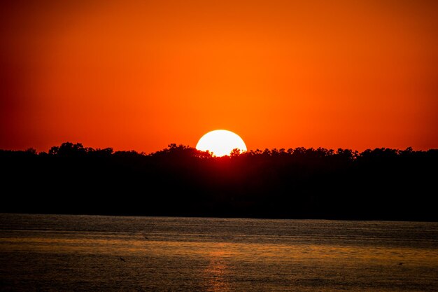 Foto schöner blick auf den see vor dem orangefarbenen himmel