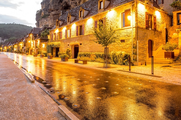 Schöner Blick auf die Straße auf das beleuchtete Dorf La Roque Gageac bei Regenwetter in Frankreich