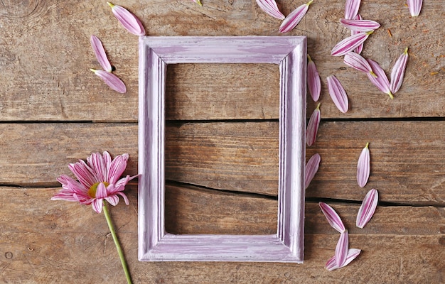 Schöner Blumen- und Fotorahmen auf hölzernem Hintergrund