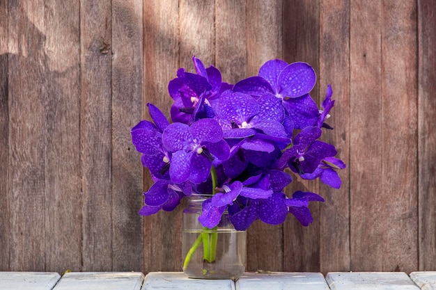 Schöner Blumenstrauß aus Orchideen Zarte rosafarbene Orchideenblüten schließen sich auf einem hölzernen Hintergrund