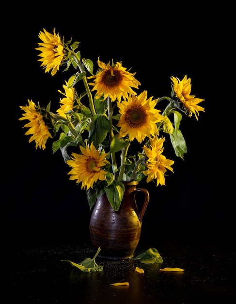 Schöner Blumenstrauß der Sonnenblumen in der Vase auf einem schwarzen Tisch