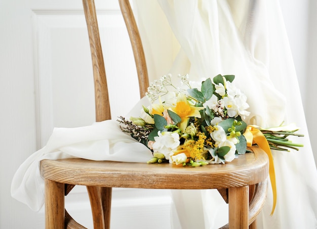 Schöner Blumenstrauß mit Freesienblumen auf Stuhl