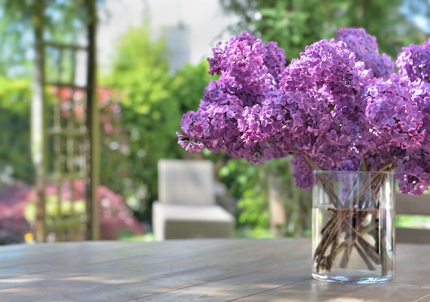 Schöner Blumenstrauß von lila lila Blumen auf einem Holztisch im Garten