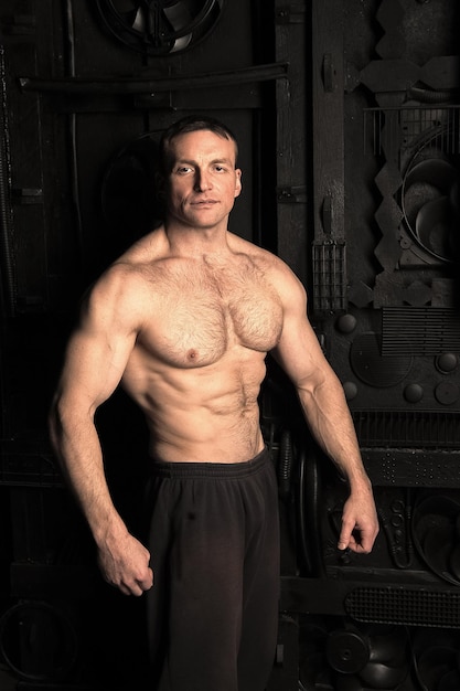 Schöner Bodybuilder mit muskulösem Körpertraining im Fitnessstudio