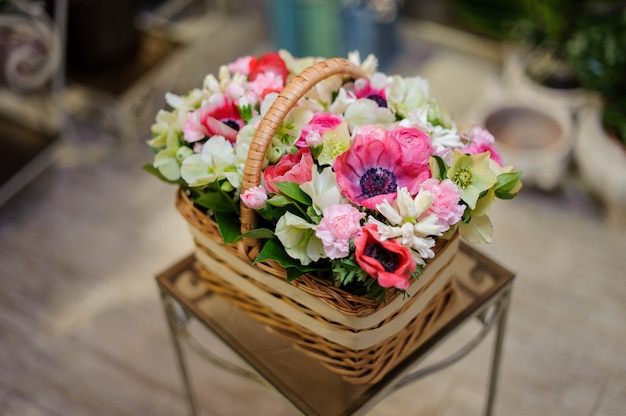 Schöner brauner Weinlesekorb der rosa und weißen Blumen