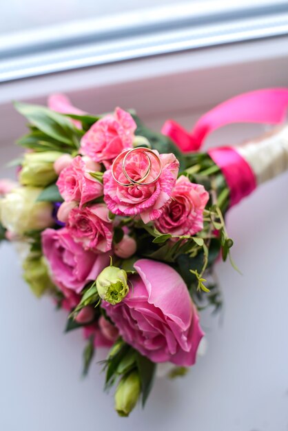 Schöner Brautstrauß aus rosa Rosen mit Eheringen drauf