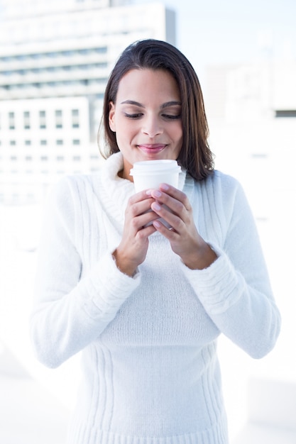 Schöner Brunette, der einen Kaffee trinkt