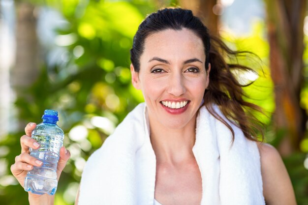 Schöner Brunette, der Flasche Wasser hält