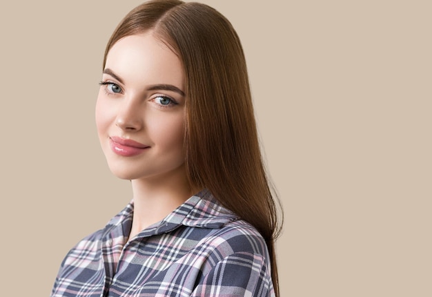 Foto schöner brunette im natürlichen porträt des karokleides. farbiger hintergrund. braun