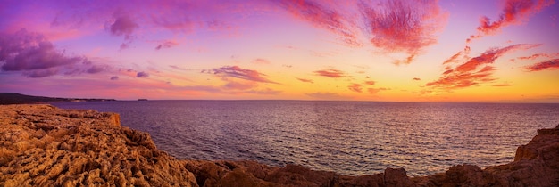 Schöner bunter Sonnenuntergang am Meer mit dramatischen Wolken. Panoramablick. Schönheitswelt natürlicher Reisehintergrund im Freien