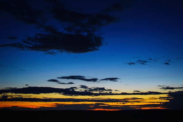 Schöner drastischer Sonnenuntergang über dem Feld