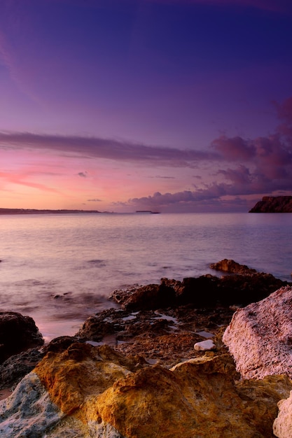 Schöner farbenfroher Sonnenaufgang am Meer mit dramatischen Wolken und Felsbrocken Schönheitswelt natürlicher Reisehintergrund im Freien