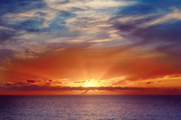 Schöner farbenfroher Sonnenuntergang am Meer mit dramatischen Wolken und Sonnenschein Schönheitswelt natürlicher Reisehintergrund im Freien