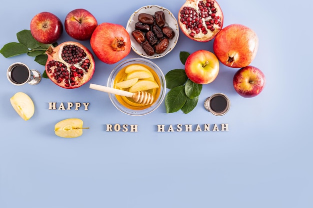 Foto schöner festlicher hintergrund für das jüdische neujahr. das konzept der traditionellen produkte von rosch haschana auf blauem hintergrund mit text von oben