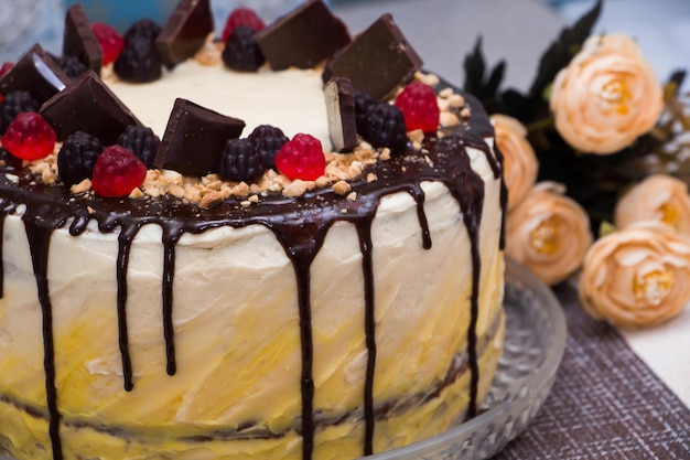 Schöner festlicher Kuchen mit Schokoladen-Glasur und Marmelade auf einem Blumen-Hintergrund