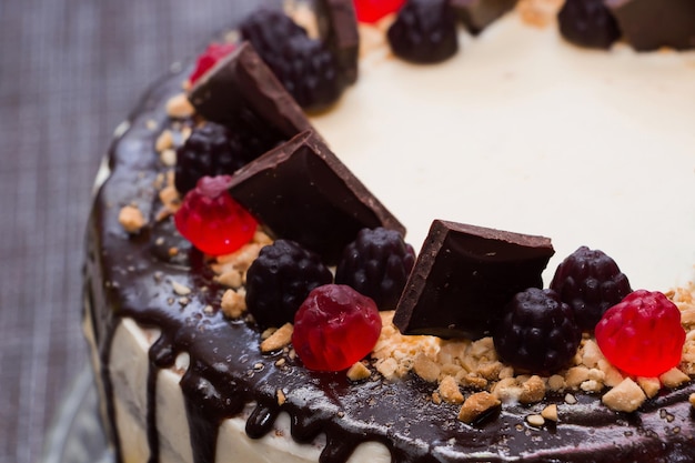 Schöner festlicher Kuchen mit Schokoladenglasur und Marmelade auf Blumenhintergrund