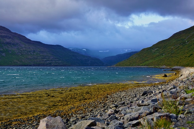 Schöner Fjord neben der Straße in Island. Geheimnisvoller bewölkter Himmel.