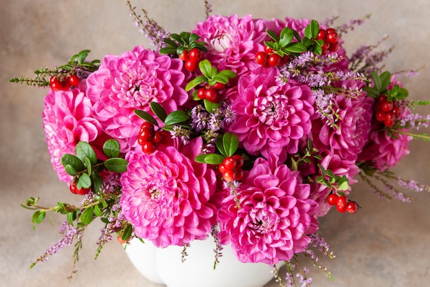 Schöner frischer Blumenstrauß von rosa Dahlien im weißen Vase.
