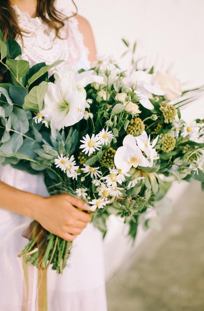 Schöner frischer Hochzeitsblumenstrauß in den Händen der Braut