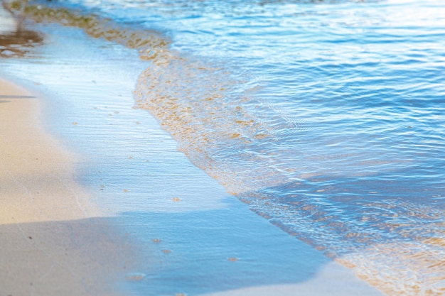 Schöner gelber Strandsand mit Meereswellen