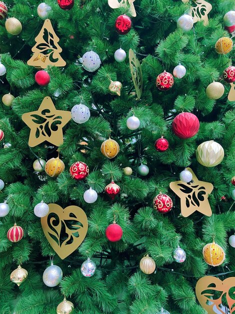 Foto schöner glänzender weihnachtsbaum mit dekorationen neujahrsbaum mit ornamenten frohe weihnachten und frohes neujahr hintergrund